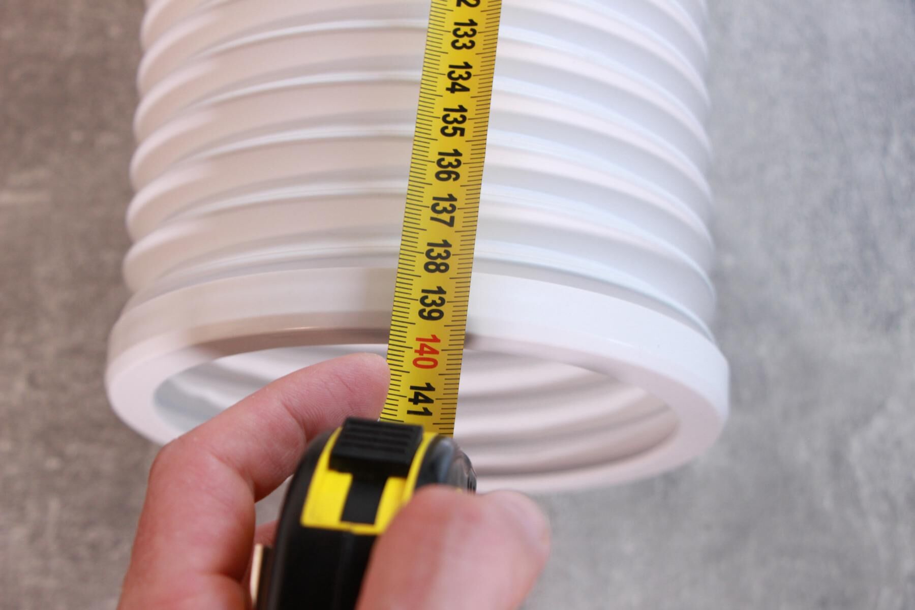 Die länge des Abluftschlauch einer mobilen Klimaanlage wird nachgemessen und das Maßband liegt bei 140 cm.